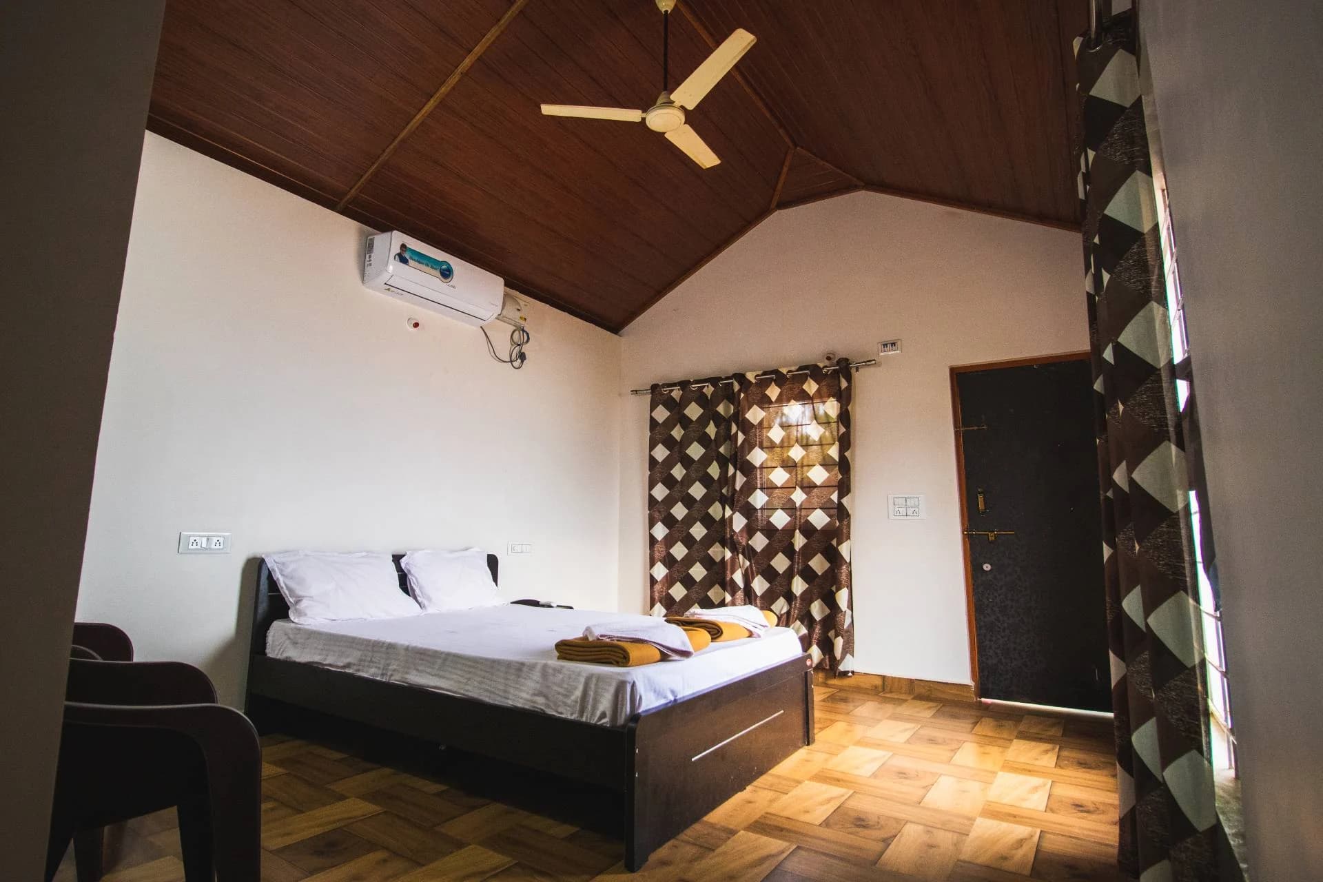 Private bedroom with a timber ceiling and garden-facing doorway at Trippr Gokarna
