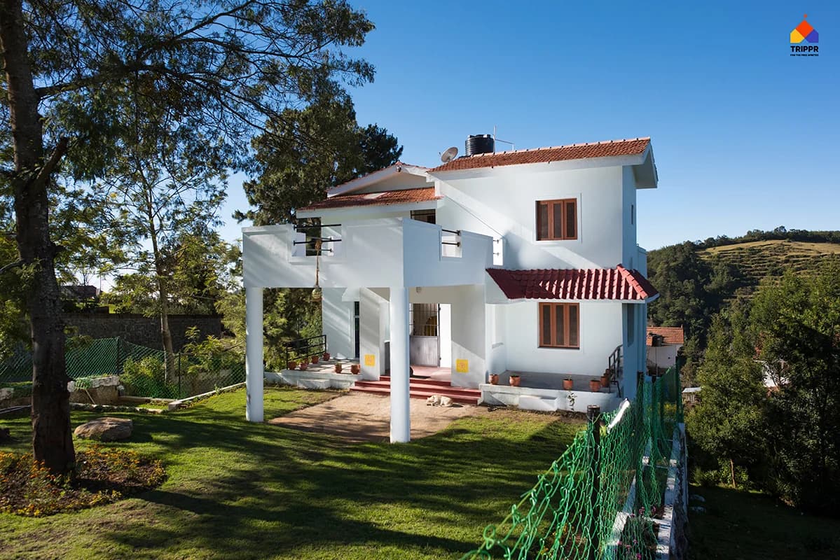 White hostel building and garden at Trippr Kodaikanal
