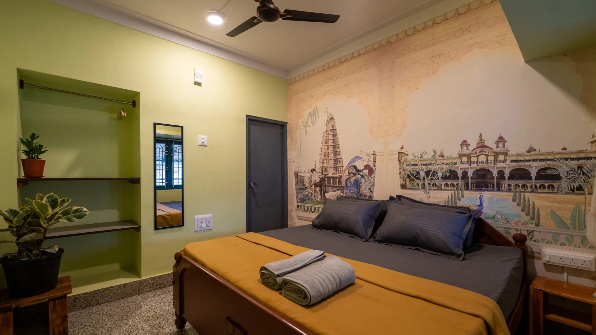 Private bedroom with a Mysuru Palace mural at Trippr Mysuru